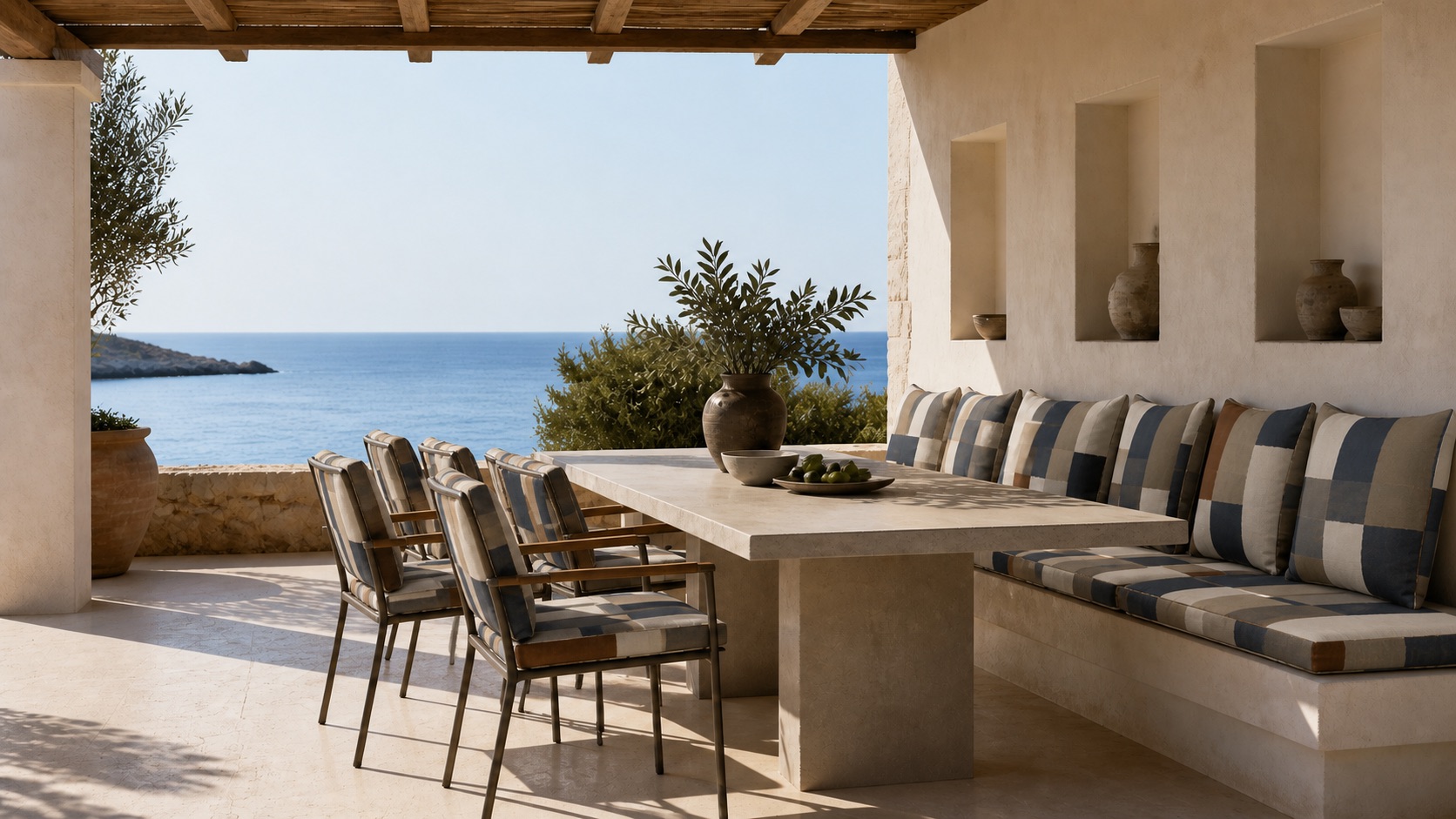 An outdoor dining setting beneath a portico, seating upholstered in the PORTICO design.